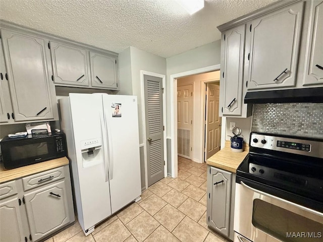 109 Lashley Dr, Selma, AL 36701 - kitchen with white refrigerator with ice dispenser, under cabinet range hood, light countertops, stainless steel electric range oven, and black microwave