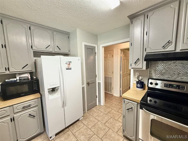 109 Lashley Dr, Selma, AL 36701 - kitchen featuring white refrigerator with ice dispenser, under cabinet range hood, light countertops, stainless steel electric range oven, and black microwave