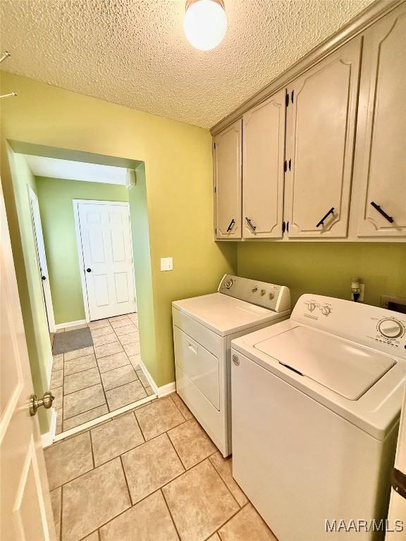 109 Lashley Dr, Selma, AL 36701 - washroom with a textured ceiling, light tile patterned flooring, cabinet space, and independent washer and dryer