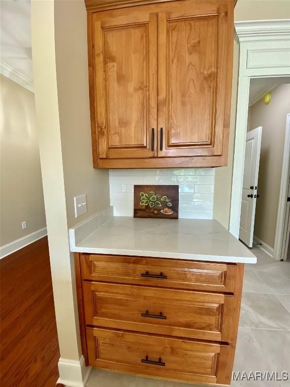 room details with ornamental molding, tasteful backsplash, and baseboards