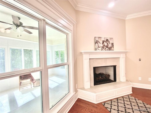 living room featuring ornamental molding, a fireplace, dark wood-style floors, a ceiling fan, and baseboards