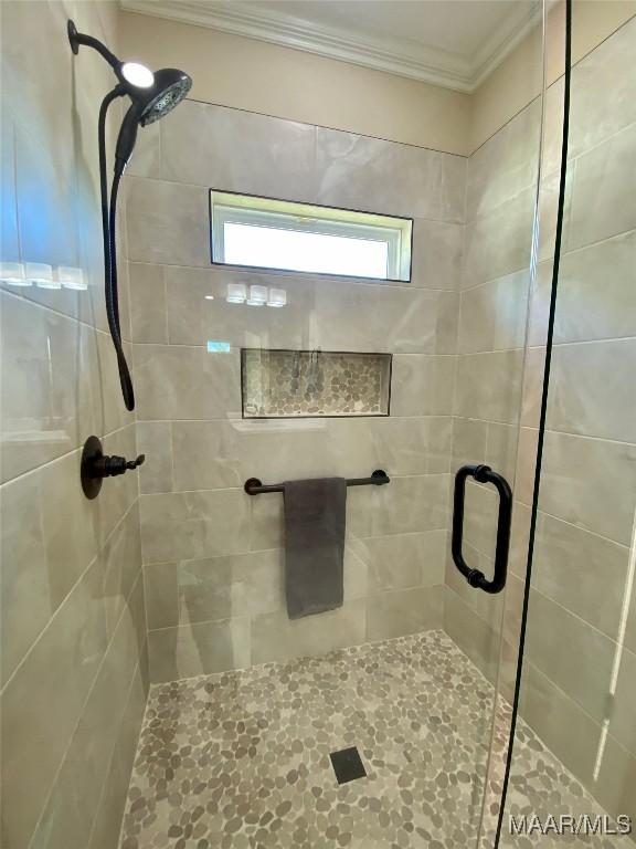 full bathroom with crown molding and a stall shower
