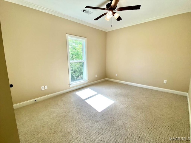 carpeted empty room with baseboards, crown molding, visible vents, and a ceiling fan