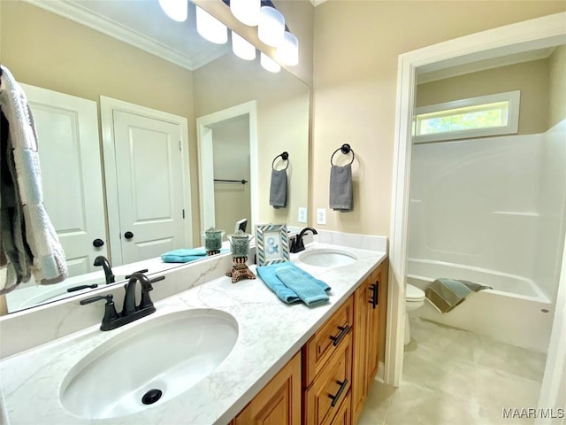 bathroom featuring double vanity, toilet, crown molding, and a sink