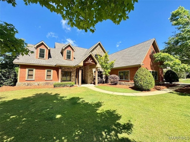 155 Edge Wood Ct, Mathews, AL 36052 - new england style home with a front lawn, a shingled roof, and stone siding