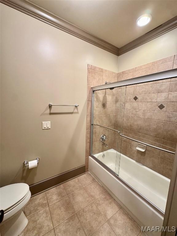 155 Edge Wood Ct, Mathews, AL 36052 - bathroom with crown molding, baseboards, shower / bath combination with glass door, toilet, and tile patterned floors