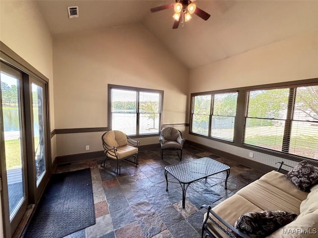 155 Edge Wood Ct, Mathews, AL 36052 - living room with stone tile floors, high vaulted ceiling, ceiling fan, baseboards, and a wainscoted wall