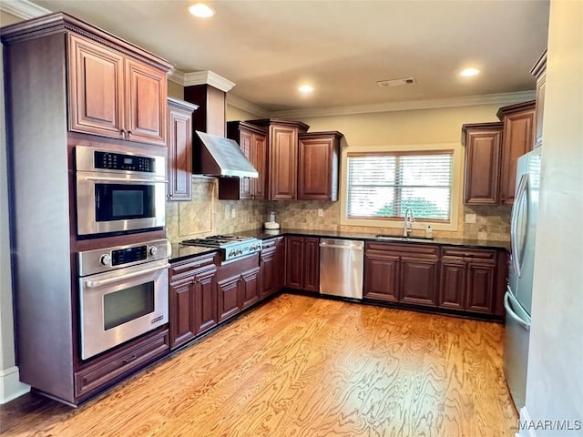 155 Edge Wood Ct, Mathews, AL 36052 - kitchen featuring appliances with stainless steel finishes, a sink, light wood finished floors, wall chimney range hood, and recessed lighting