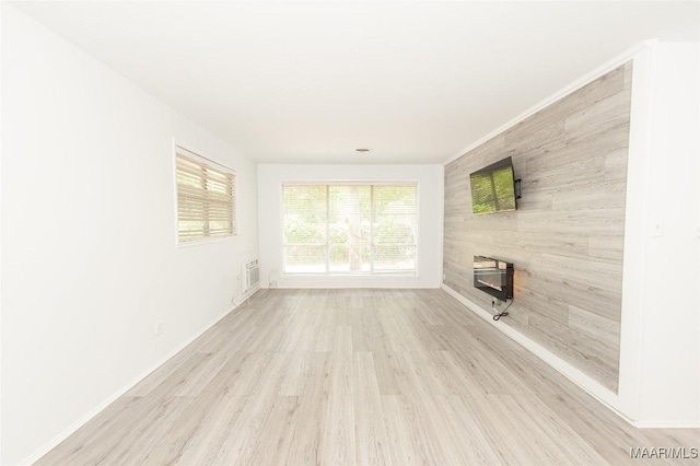 1701 Sylvan Dr, Montgomery, AL 36106 - unfurnished living room featuring wood finished floors, baseboards, and an AC wall unit