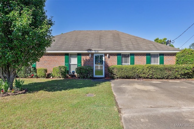 ranch-style house with a front lawn, brick siding, and roof with shingles