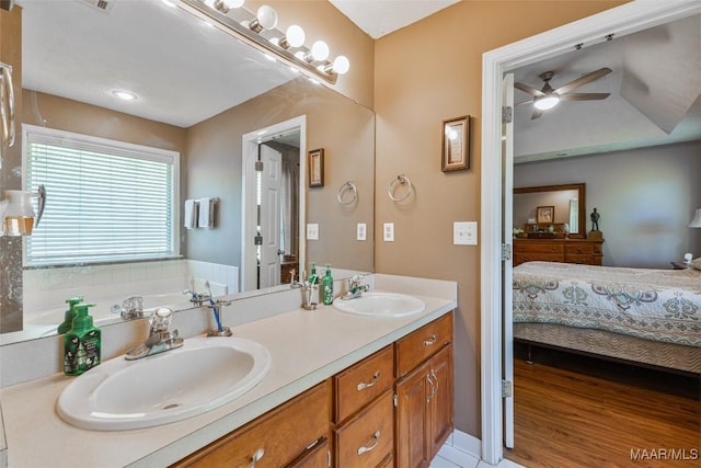 bathroom with a ceiling fan, connected bathroom, double vanity, and a sink