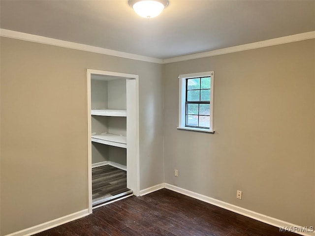 unfurnished room with ornamental molding, baseboards, and dark wood-type flooring