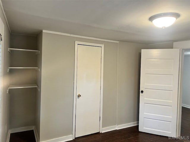 unfurnished bedroom featuring baseboards and dark wood finished floors