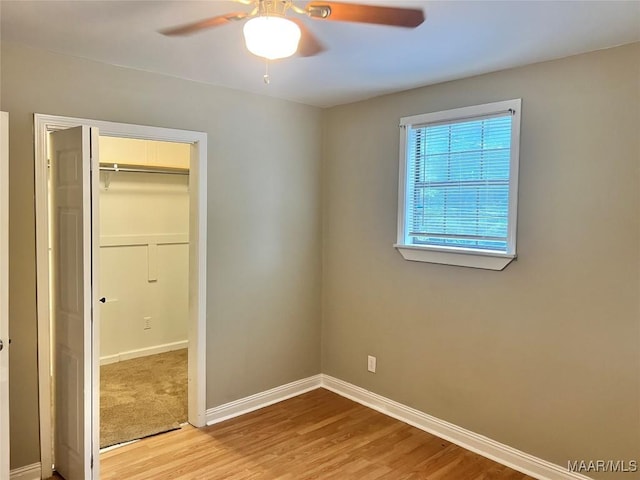 unfurnished bedroom with baseboards, light wood finished floors, and a closet