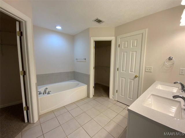 1939 Cedar Ridge Loop, Prattville, AL 36067 - bathroom featuring tile patterned flooring, a spacious closet, a garden tub, double vanity, and recessed lighting