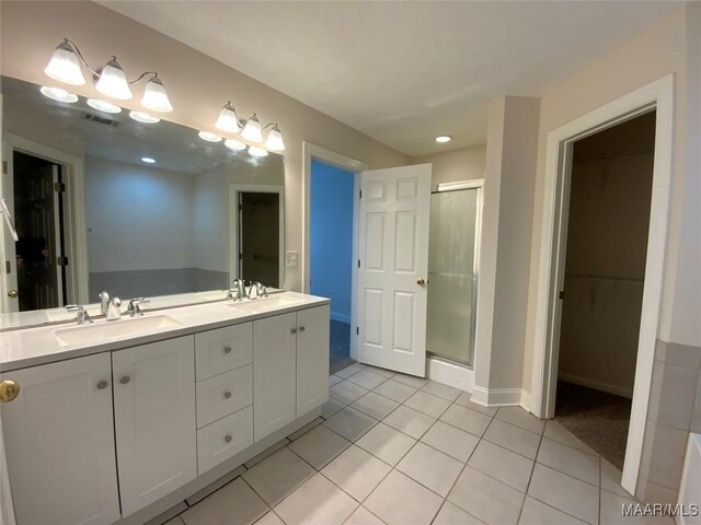 1939 Cedar Ridge Loop, Prattville, AL 36067 - full bathroom featuring a stall shower, double vanity, a spacious closet, tile patterned flooring, and baseboards