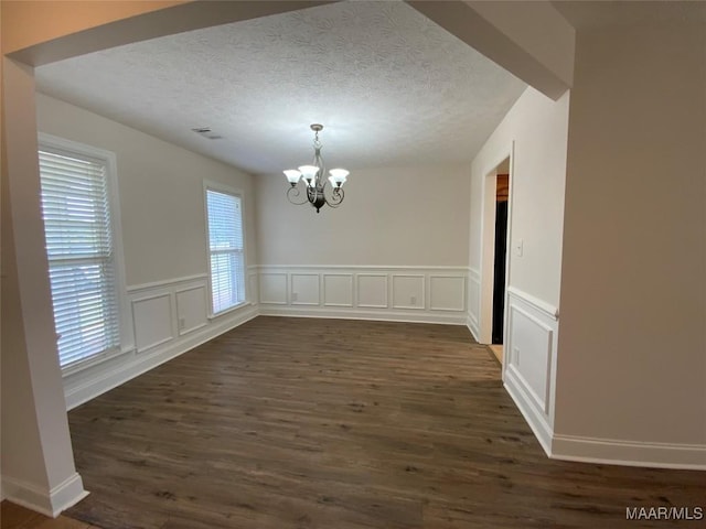 1939 Cedar Ridge Loop, Prattville, AL 36067 - unfurnished dining area with a chandelier, dark wood-style flooring, a textured ceiling, a wainscoted wall, and a decorative wall