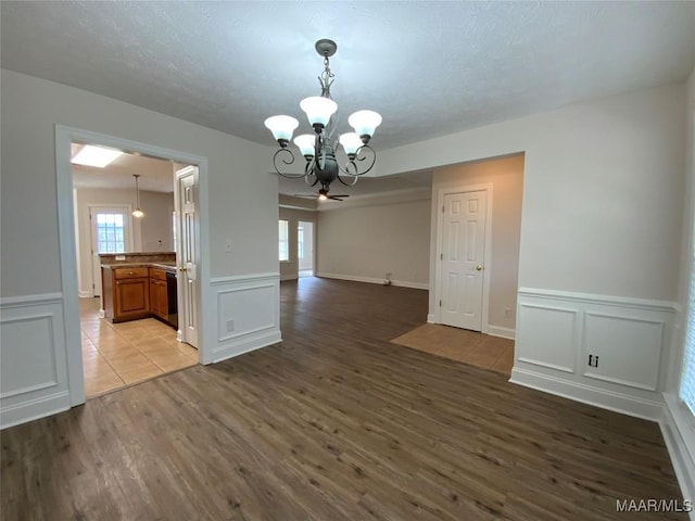 1939 Cedar Ridge Loop, Prattville, AL 36067 - unfurnished room with a chandelier, a decorative wall, wood finished floors, a wainscoted wall, and a textured ceiling