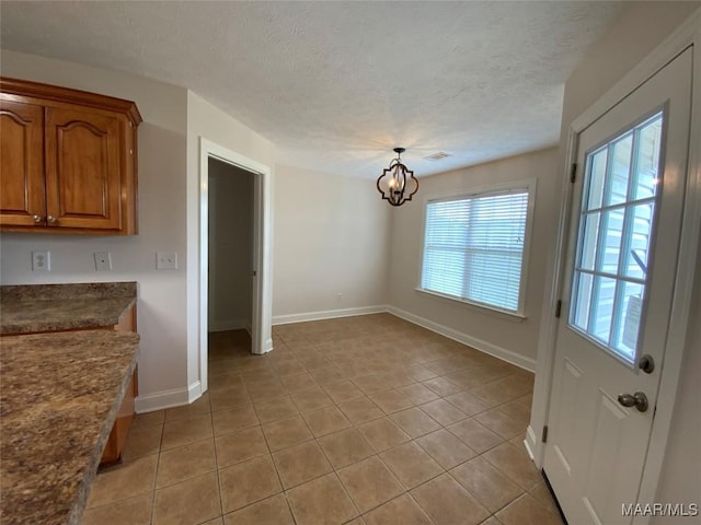 1939 Cedar Ridge Loop, Prattville, AL 36067 - unfurnished dining area featuring light tile patterned flooring, a chandelier, baseboards, and a textured ceiling