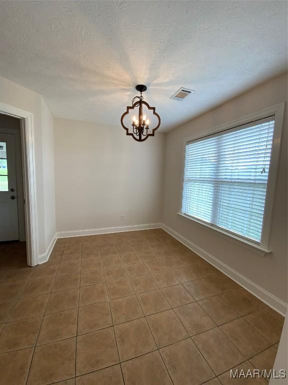 1939 Cedar Ridge Loop, Prattville, AL 36067 - tiled empty room featuring a chandelier, baseboards, and a textured ceiling