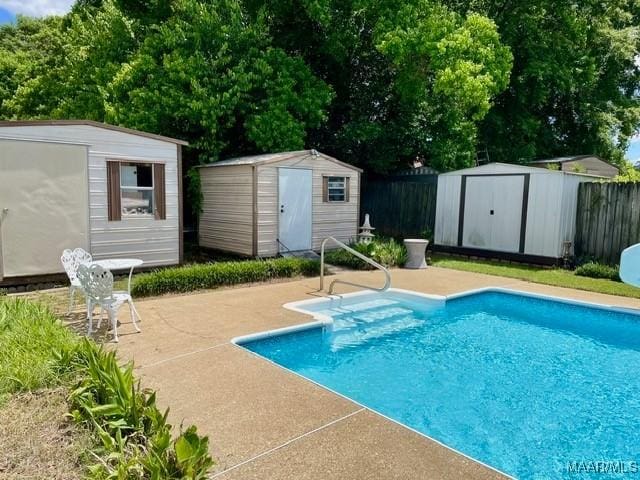 view of pool featuring a storage unit, an outbuilding, and fence