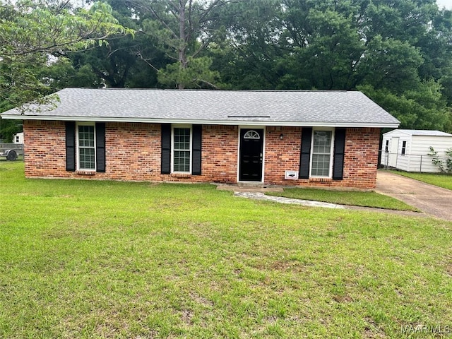 ranch-style home featuring a front lawn, brick siding, and roof with shingles