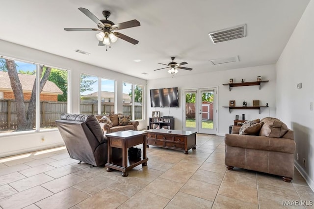 living area with light tile patterned flooring, visible vents, french doors, and a ceiling fan