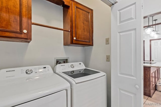 washroom featuring light tile patterned floors, independent washer and dryer, and cabinet space
