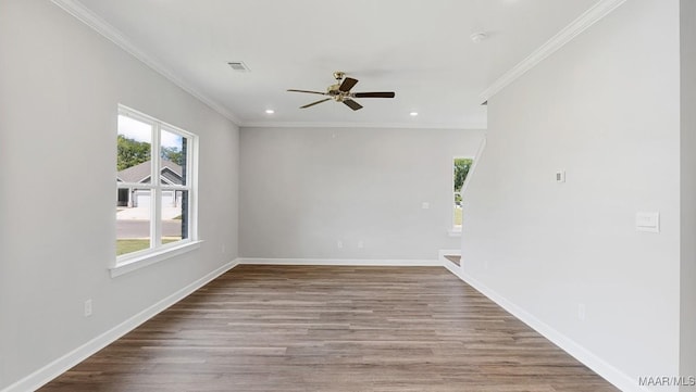 spare room featuring wood finished floors, recessed lighting, ceiling fan, crown molding, and baseboards