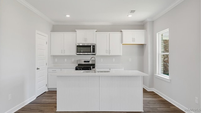 kitchen with white cabinets, a kitchen island with sink, baseboards, light countertops, and appliances with stainless steel finishes