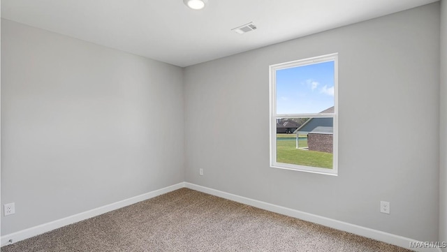 carpeted spare room featuring baseboards and visible vents