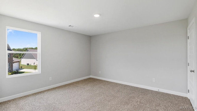 empty room featuring baseboards and carpet floors