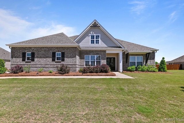 craftsman-style home featuring brick siding, roof with shingles, and a front yard