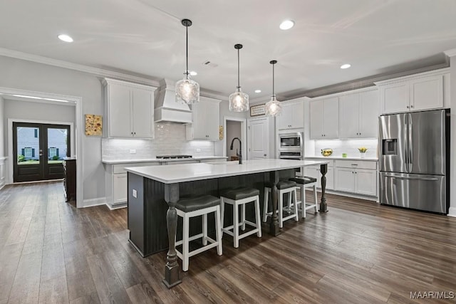 kitchen featuring a sink, stainless steel appliances, white cabinets, light countertops, and premium range hood