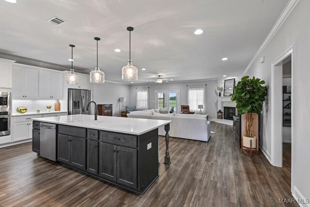 kitchen with ornamental molding, white cabinets, appliances with stainless steel finishes, and a sink