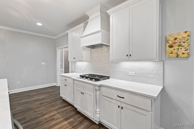 kitchen featuring light countertops, stainless steel gas stovetop, premium range hood, and baseboards