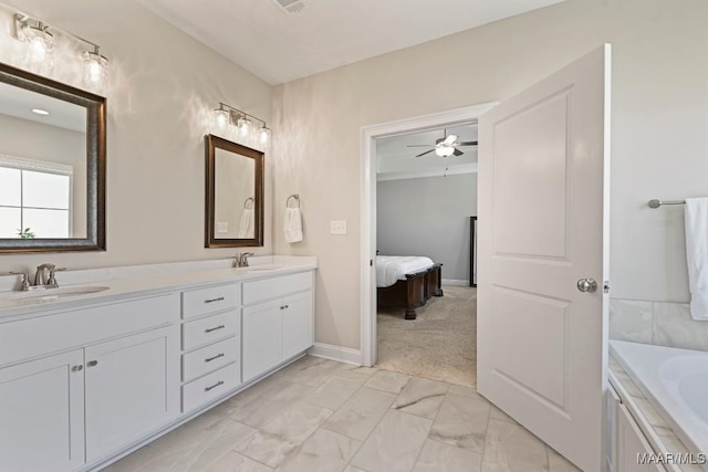 bathroom featuring double vanity, a bathtub, marble finish floor, and a sink