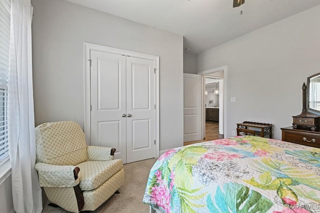 bedroom with ceiling fan, carpet flooring, and a closet