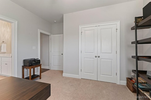 home office featuring baseboards and light carpet