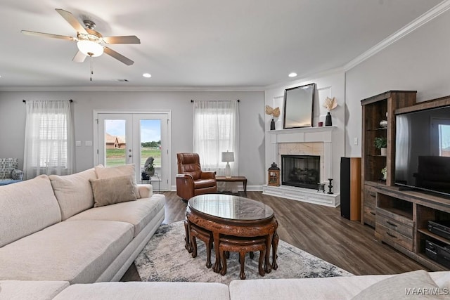 living room featuring wood finished floors, ornamental molding, recessed lighting, a ceiling fan, and a glass covered fireplace