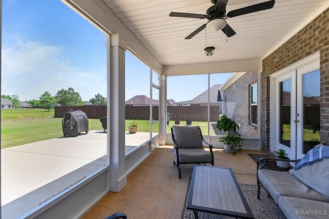 sunroom featuring a ceiling fan, an outdoor living space, and french doors
