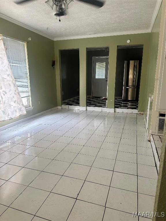 5545 E Shades Valley Dr, Montgomery, AL 36108 - unfurnished room featuring light tile patterned floors, baseboards, crown molding, and a textured ceiling