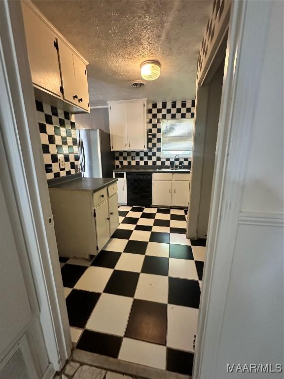 5545 E Shades Valley Dr, Montgomery, AL 36108 - kitchen with freestanding refrigerator, black dishwasher, a sink, tile patterned floors, and dark countertops