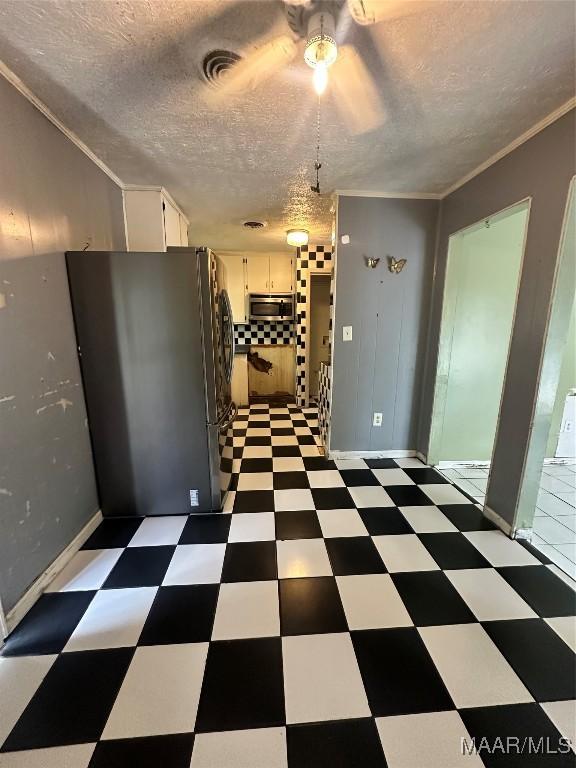 5545 E Shades Valley Dr, Montgomery, AL 36108 - unfurnished dining area featuring a ceiling fan, ornamental molding, tile patterned floors, and a textured ceiling