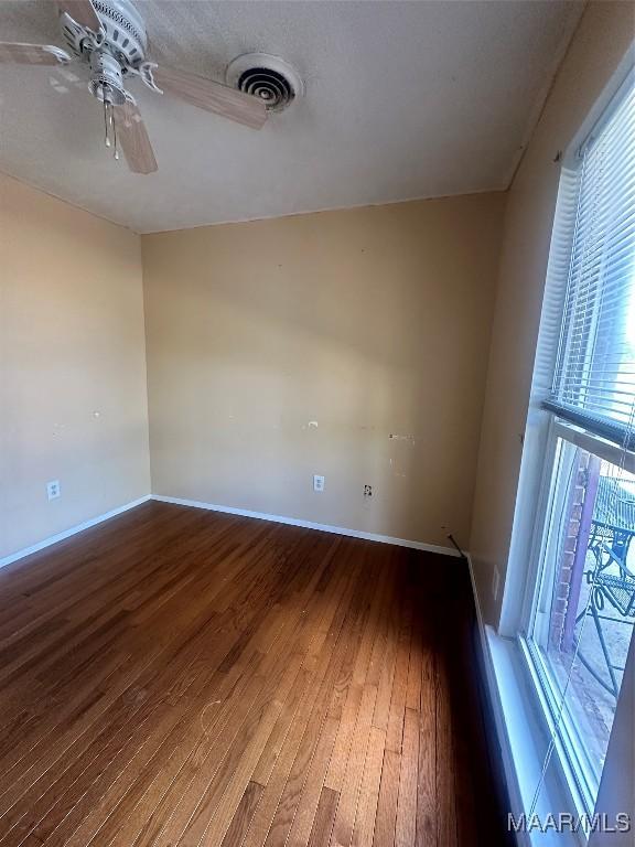 5545 E Shades Valley Dr, Montgomery, AL 36108 - empty room featuring a ceiling fan, baseboards, a healthy amount of sunlight, and wood finished floors