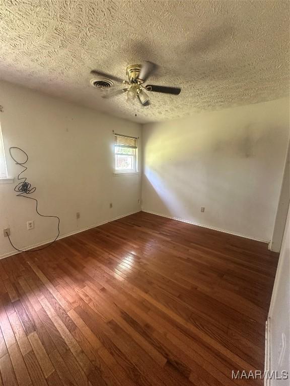 5545 E Shades Valley Dr, Montgomery, AL 36108 - empty room featuring a textured ceiling, visible vents, a ceiling fan, and wood-type flooring