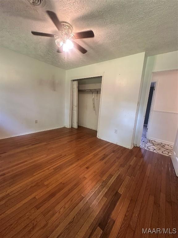 5545 E Shades Valley Dr, Montgomery, AL 36108 - unfurnished bedroom with a textured ceiling, a closet, hardwood / wood-style floors, and a ceiling fan