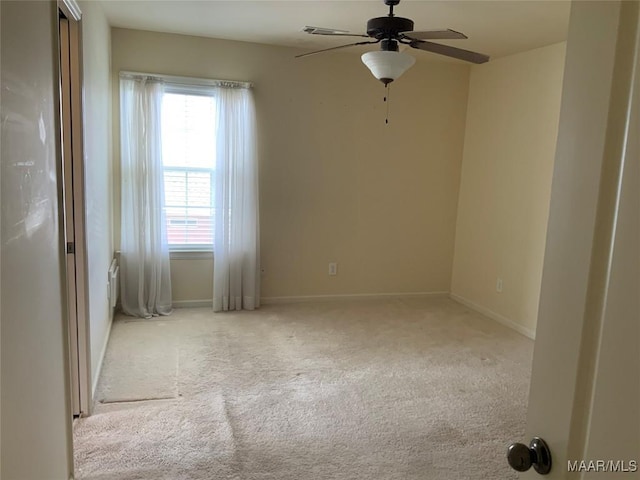 empty room with ceiling fan, carpet floors, and baseboards