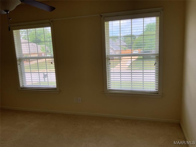carpeted spare room with baseboards and ceiling fan