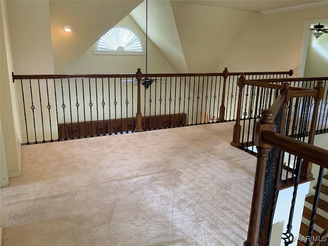 interior space featuring lofted ceiling, carpet flooring, and crown molding